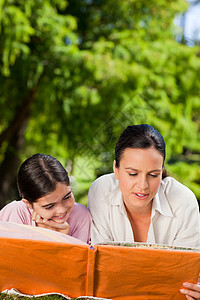 母亲和女儿在看相册上的照片时微笑幸福父母孩子生活女性家庭喜悦快乐乐趣图片