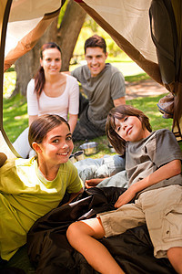 快乐的家庭在公园露营团体女儿童年帐篷孩子父亲闲暇路由器树木女士图片