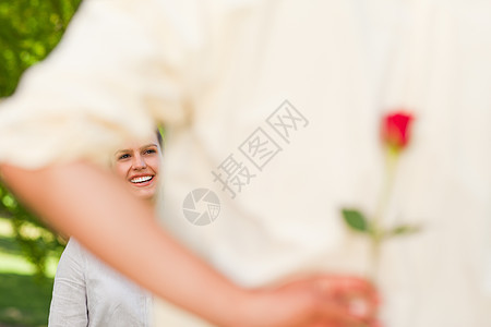 男人给他的女朋友献玫瑰投标周年礼物公园男性压痛女士微笑夫妻女性图片