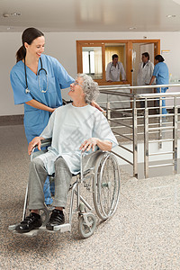 护士对坐在轮轮椅上的老年妇女微笑图片
