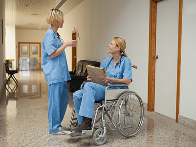喝着酒的护士 用文件夹和轮椅护士说话背景图片