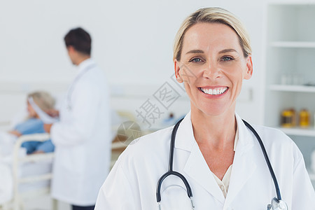 带着背景医生看病的病人 微笑着笑金发医生图片