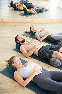 带垫子的恢复性瑜伽 一群年轻的运动有魅力的人在瑜伽室里 躺在垫子上 在恢复性瑜伽中伸展和放松 健康积极的生活方式课程保健身体训练图片