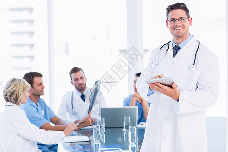 医生在会见同事时使用数字平板电脑触摸屏笔记本卫生合作团队办公室医院混血服务男人图片