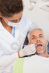 牙科医生检查牙医椅子上的病人牙齒牙科卫生专业工具口腔口罩男人职业口腔科考试图片