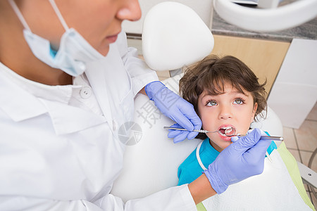 儿科牙医 检查牙椅上小男孩牙齿的情况卫生考试设备女士口镜男性斜角镜女性工作牙科图片