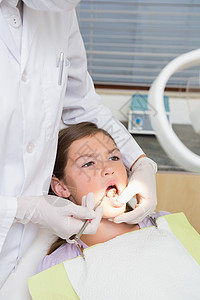 儿科牙医 检查牙椅上一个小女孩牙齿的牙片设备手术医学专业孩子工作医疗手套病人女孩背景图片