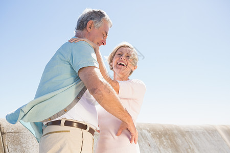 高级女人拥抱她的伴侣微笑退休男人感情老年女士夫妻休闲衬衫女性背景图片