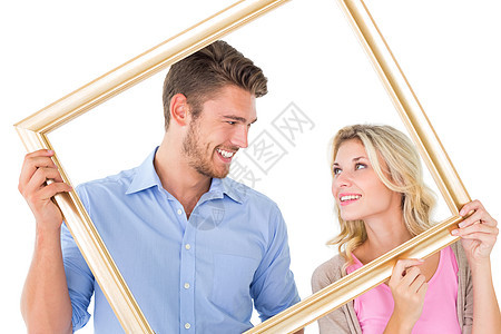 富有吸引力的年轻夫妇持有图片框架微笑感情女朋友服装双手夫妻女性衬衫男性休闲图片