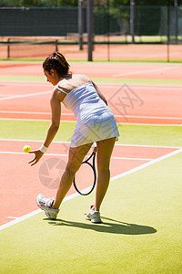漂亮的网球选手即将上任裙子运动服务法庭专注球拍女性生活方式闲暇训练图片