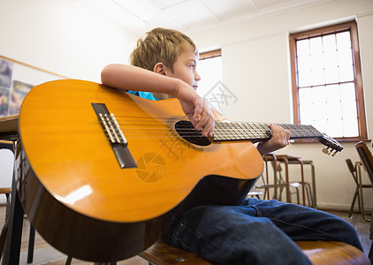 在课堂上弹吉他的小可爱学生椅子早教学习学校小学生乐器微笑音乐弹奏班级背景图片