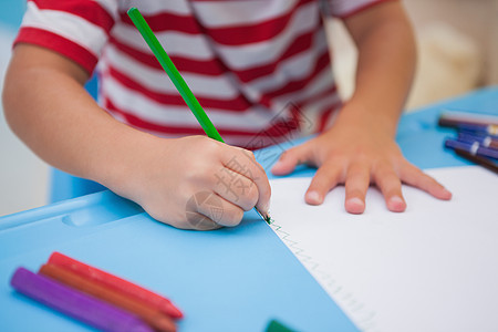 可爱的小男孩在书桌上画画班级课堂铅笔绘画男性童年男生幼儿园早教创造力图片