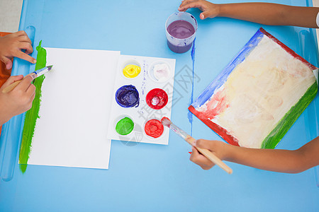 可爱的小男孩在课堂上桌边画画班级红色画笔围裙早教绘画教育创造力男生艺术类图片
