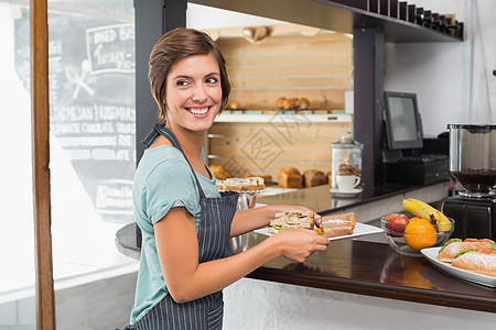 漂亮的女服务员拿着一盘食物女性微笑餐厅制服快乐盘子咖啡屋咖啡师午餐店铺图片
