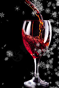 积雪降雪的复合图像饮料高脚杯酒精红色下雪雪花微光反射背景图片