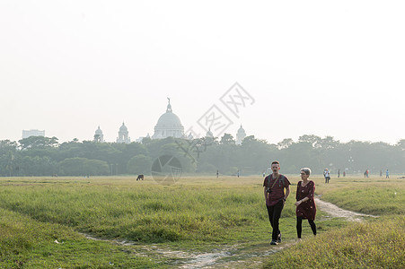 夏季日落时分 旅游度假夫妇在广场的 Maidan 玩耍花园区散步 在遥远的草地背景下的著名维多利亚纪念碑 加尔各答 西孟加拉邦 图片