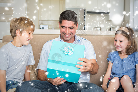 儿童在沙发上赠送父亲礼物的复合形象计算机女儿女孩男生房子绘图兄弟姐妹礼物盒男性下雪图片