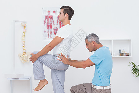 医生给他的病人做复诊检查姿势拉伸臀部矫正昏睡从业者男性理疗脊椎药品图片