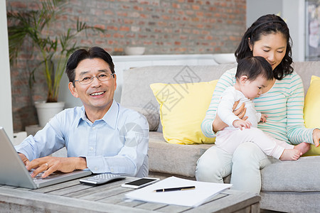 微笑的男人在客厅数帐单图片