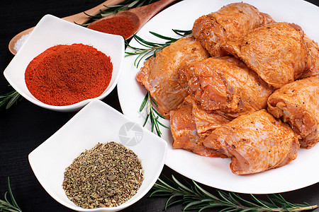 生鸡肉被红色 番茄腌料和香料包裹在白盘子里 腌生肉 膳食肉类 烹饪 鸡大腿 香料 辣椒图片