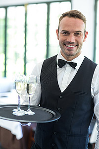 端着香槟的服务员男人马甲领结酒店男性奢华服务托盘长笛玻璃图片