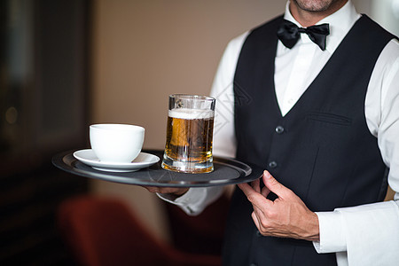 拿着啤酒托盘的服务员衬衫酒店男人玻璃餐厅马甲杯子服务男性领结图片