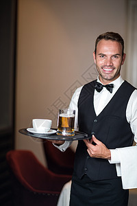 拿着啤酒托盘的服务员服务微笑领结餐厅男人玻璃男性马甲杯子衬衫图片