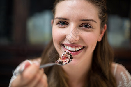 带着沙漠微笑的女人的肖像控股饮食盘子甜点享受诱惑甜食顾客女士幸福图片