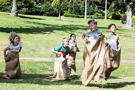 孩子们在公园里打麻布比赛草地喜悦草原男生跳跃乐趣农村享受混血快乐图片