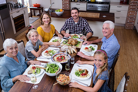 在厨房用餐的多代家庭肖像图象图片