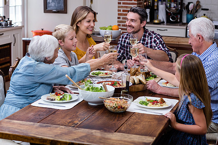 多代多代家庭在用餐时举红酒杯女性房子女孩午餐孙子服装休闲感情晚餐家庭生活图片