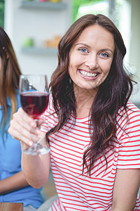 美丽的女人拿着一杯红葡萄酒家庭公寓闲暇酒精喜悦服装房子快乐住所女士图片