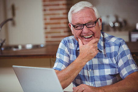 带着笔记本电脑微笑的老人肖像图片