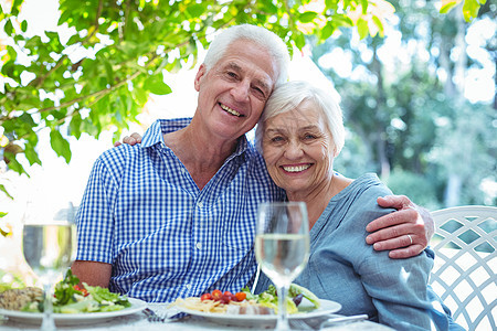 幸福的退休夫妇 手放在桌子上图片