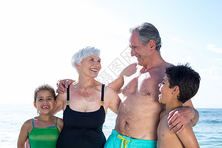 在海滩上和孙子孙女一起玩得开心的老奶奶图片