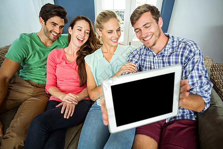 微笑的朋友在数字平板电脑上自拍图片