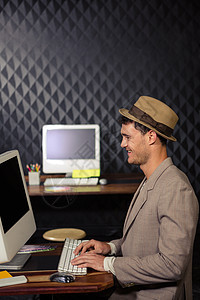 使用计算机的创意商家男性职业帽子桌子键盘套装工作设计师机构休闲图片