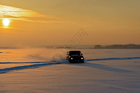 汽车在日落的光线下穿过冰冻河流的雪 开着汽车图片