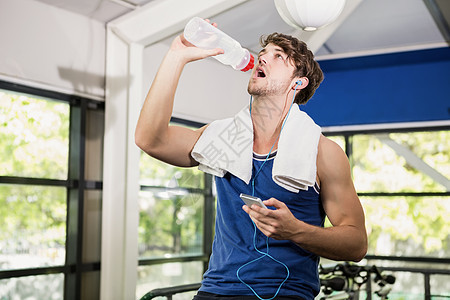 男子在运动时饮用饮用水图片