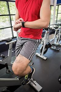 运动时使用智能手表的人训练竞技男性触摸屏进度男人健身室体质锻炼纺纱类图片