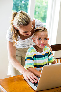 在家里使用笔记本电脑的幸福母亲和儿子图片