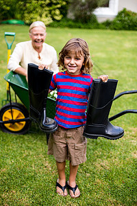 男孩在院子里站着时穿着惠灵顿靴子图片