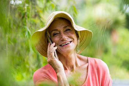 年长妇女在院子里通过电话交谈图片
