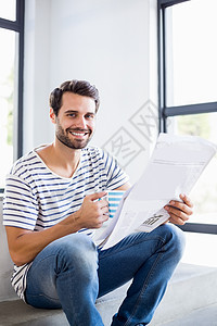欢乐男人的肖像 站在举着咖啡杯和阅读报纸的台阶上服装家庭男性公寓家庭生活新闻窗户微笑休闲快乐图片