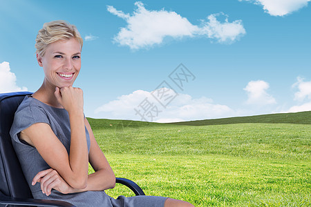 坐在椅子上笑笑的女商务人士肖像综合图象蓝天浅色工作商务短发职业人士金发女郎公司场地图片