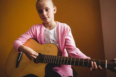 女孩弹吉他童年黄色学习歌曲吉他音乐闲暇背景音乐家旋律图片