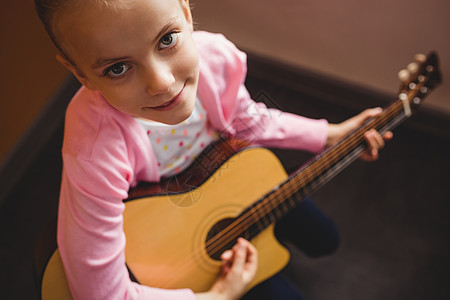 女孩弹吉他女性乐器黄色音乐家旋律童年享受音乐艺术家学习图片