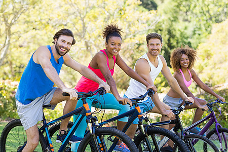 准备骑自行车的朋友们小组享受微笑女士黑色公园闲暇朋友乐趣活动混血图片