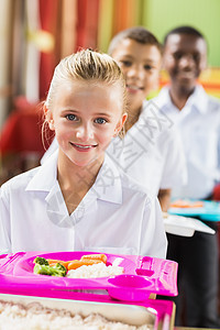 女学生在休息时间吃午饭的肖像快乐幼儿园学校蔬菜托盘午餐孩子们男性教育女性图片