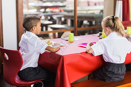 在食堂吃午餐时穿校服的男男女女蔬菜知识学校食物童年教育男性孩子们桌子瞳孔图片